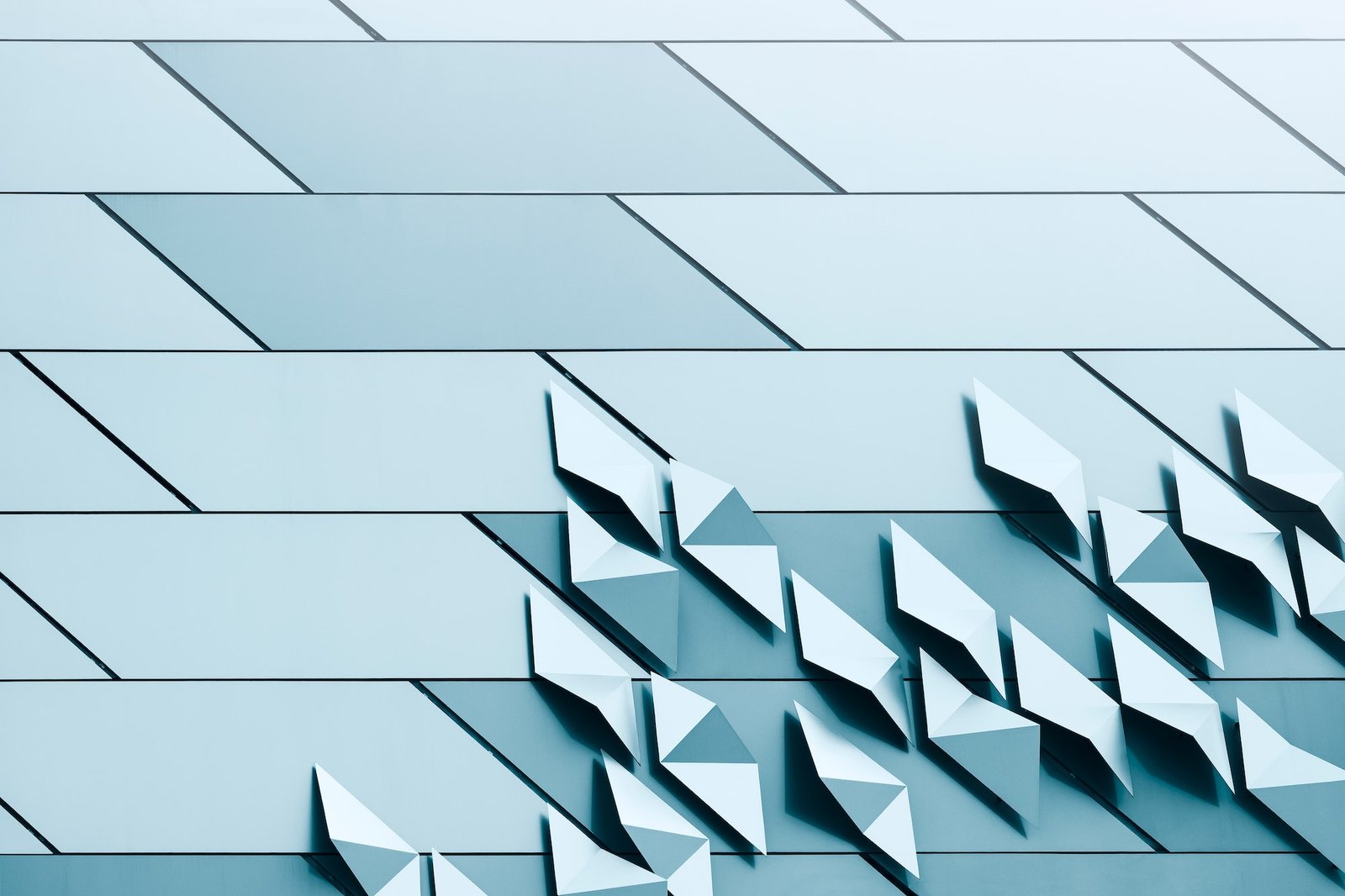 geometric pattern of stainless steel plates on tile wall of modern building in monochrome style